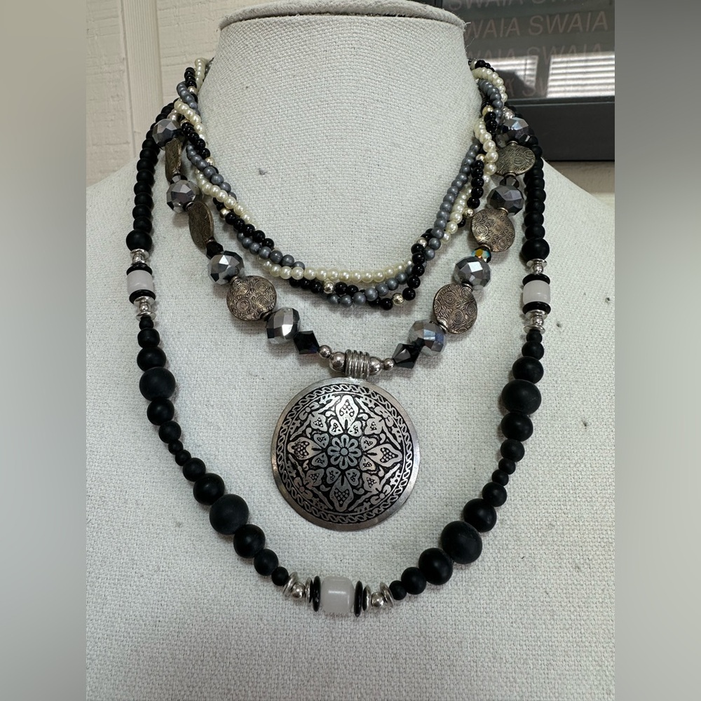 Three silvertone and black statement necklaces
